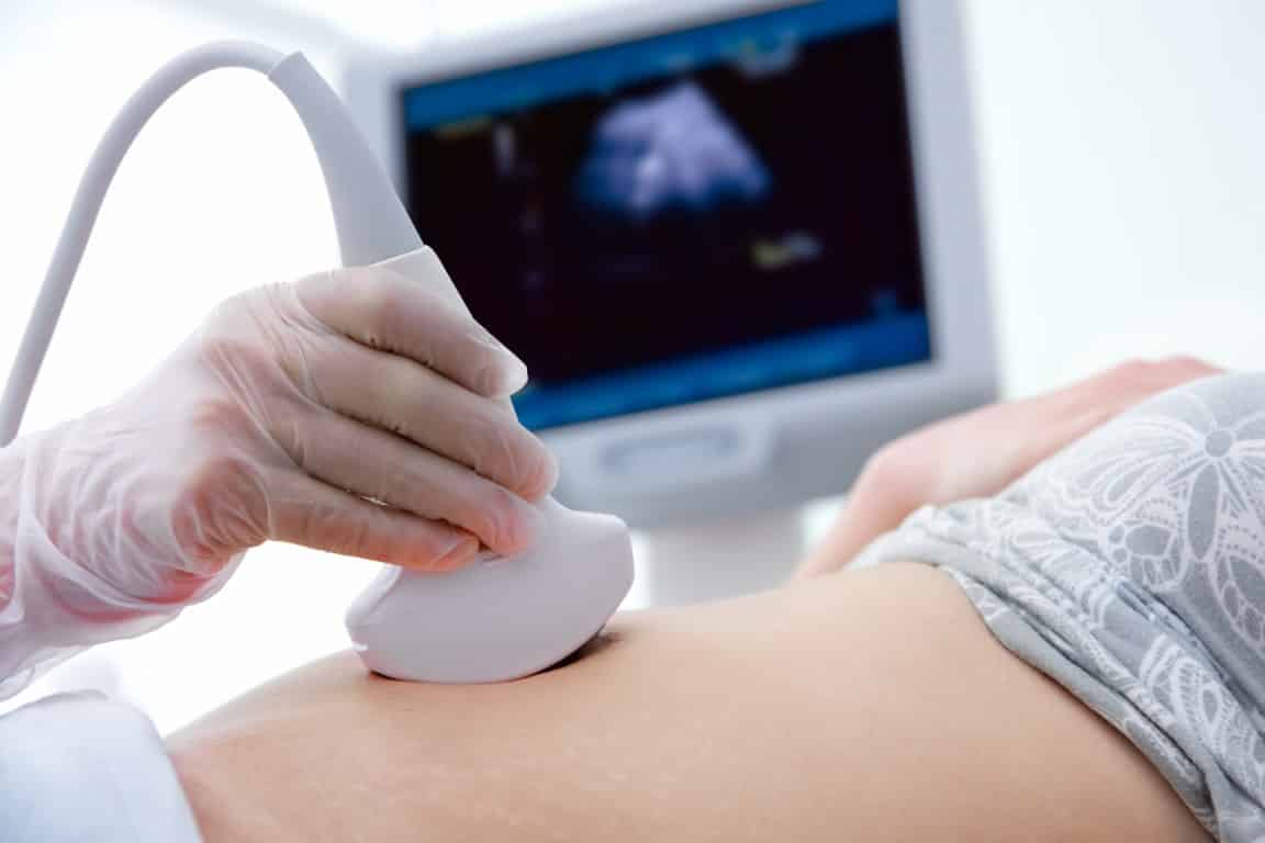 Première échographie sur le ventre d'une femme enceinte